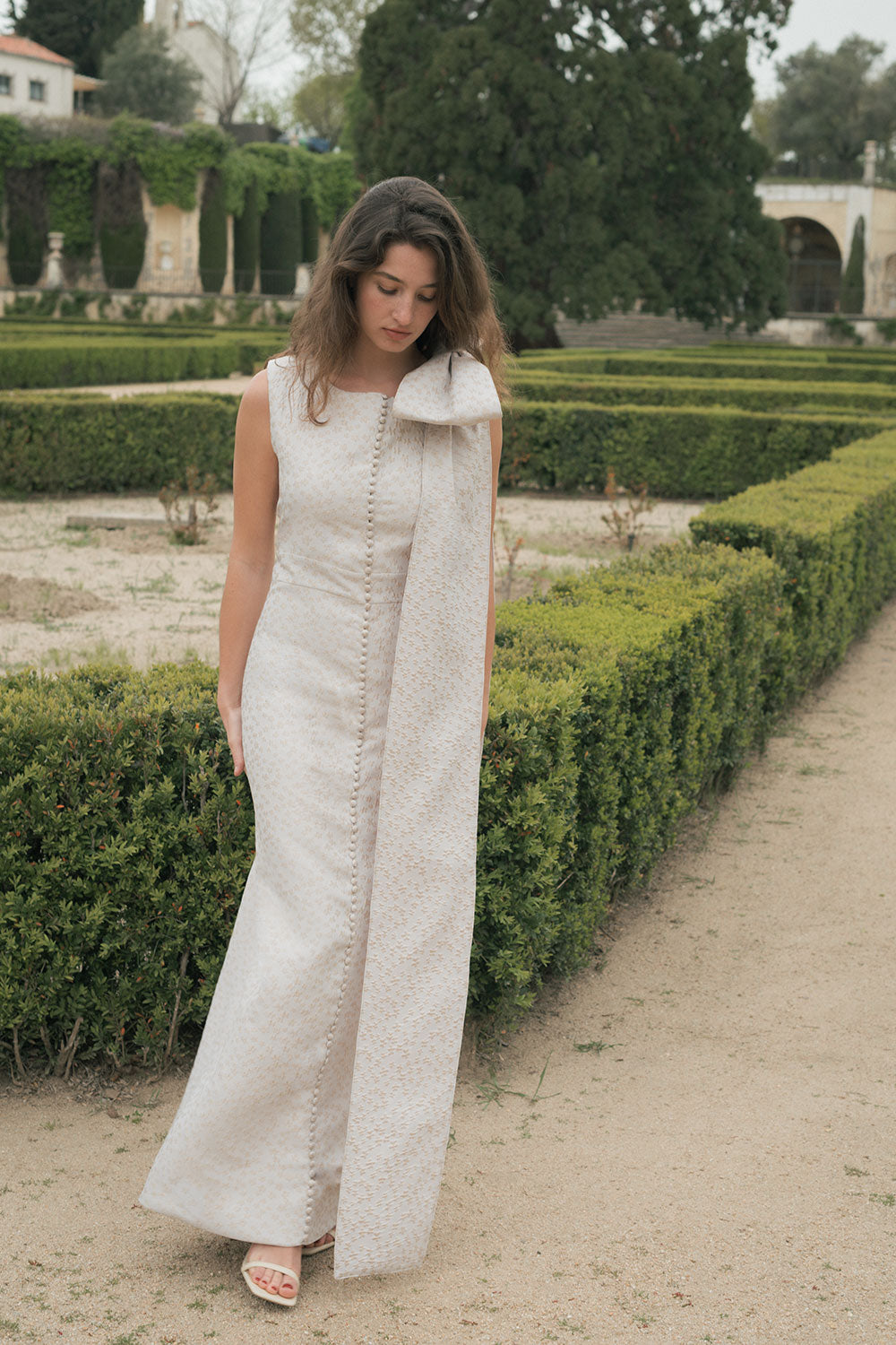 Vestido de corte recto confeccionado en Jacquard de flores con manga sisa y lazo desmontable en hombro.