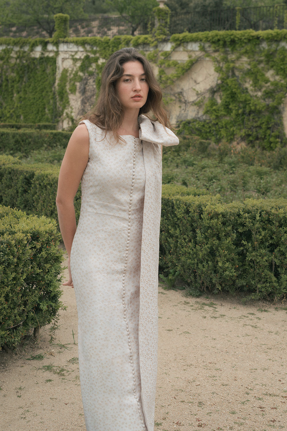 Vestido Cloe es de corte recto confeccionado en Jacquard de flores con manga sisa y lazo desmontable en hombro.
